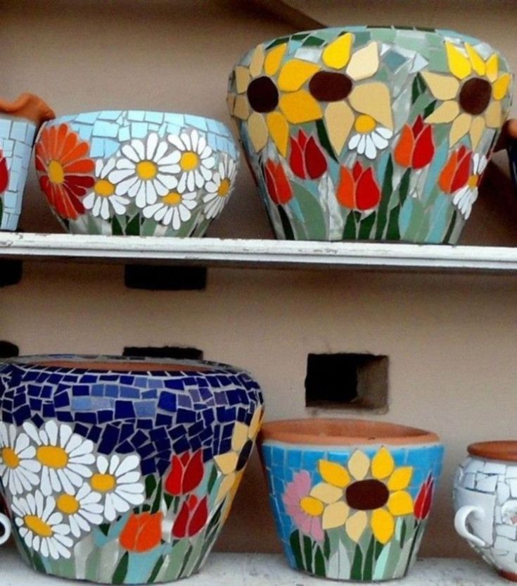 colorful vases and bowls are on display in a store window, painted with flowers