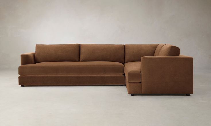 a brown couch sitting on top of a white floor