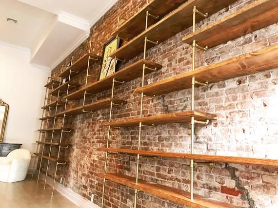 a brick wall with wooden shelves on it