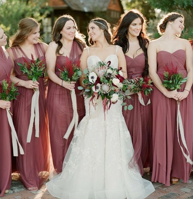 the bride and her bridesmaids are all dressed in burgundy dresses with matching bouquets