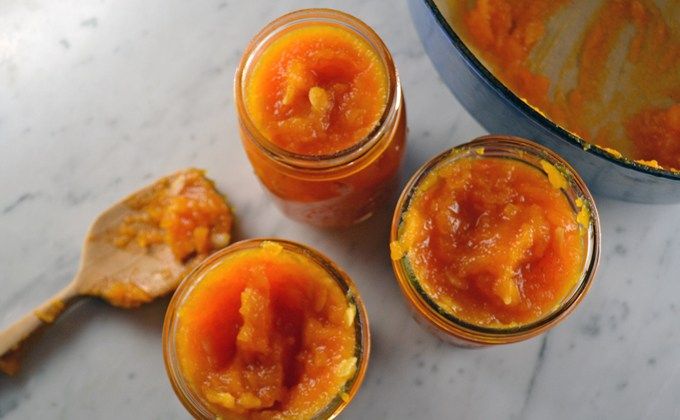 three jars filled with food sitting on top of a counter next to a wooden spoon