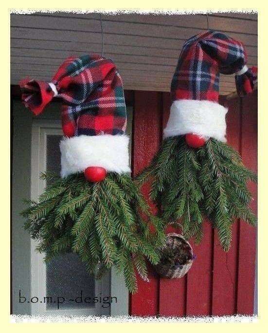 two christmas wreaths hanging from the side of a red door with plaid hats on them