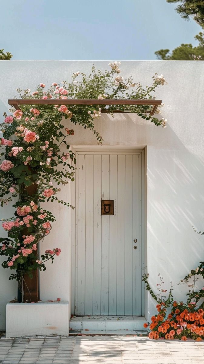 a white door with pink flowers growing over it