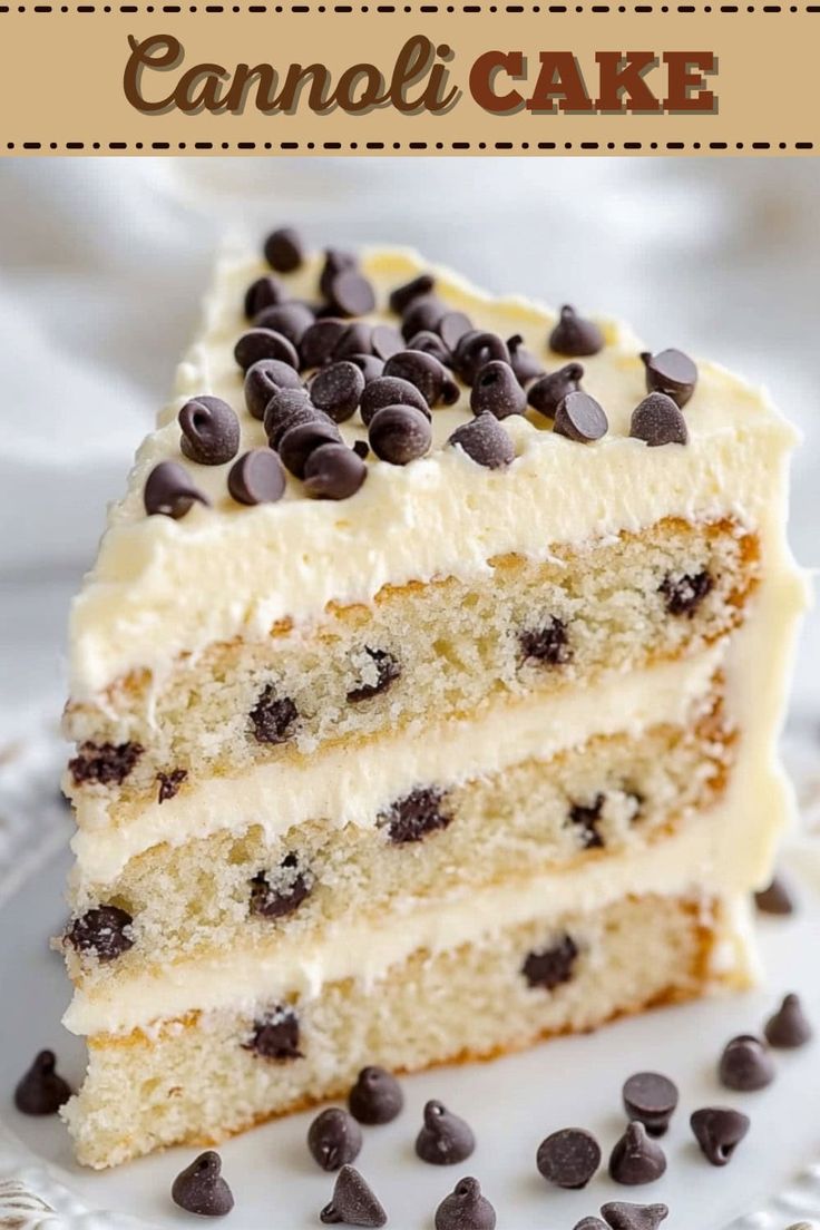 a close up of a slice of cake with white frosting and chocolate chips on top