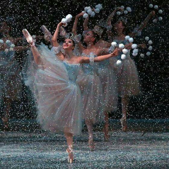 a group of ballerinas are dancing in the rain