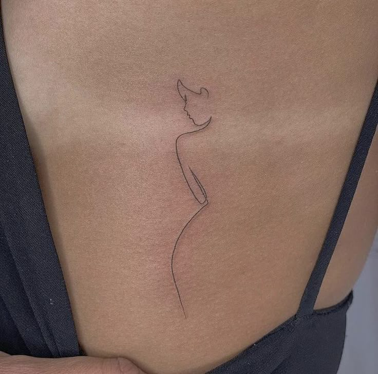 a woman's stomach with a small tattoo on the side of her belly, which has a line drawing of a female figure