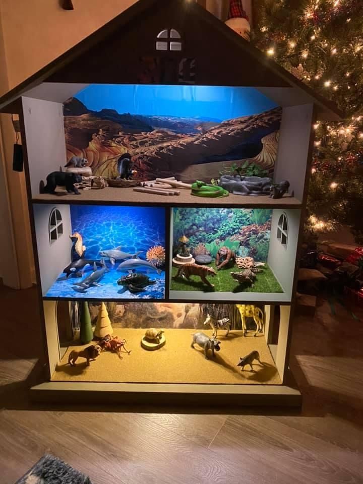 a house made out of different types of fish and other things on display in front of a christmas tree