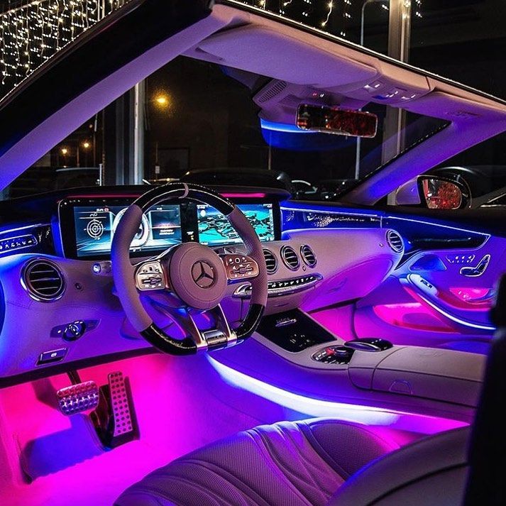 the interior of a car with purple and blue lights