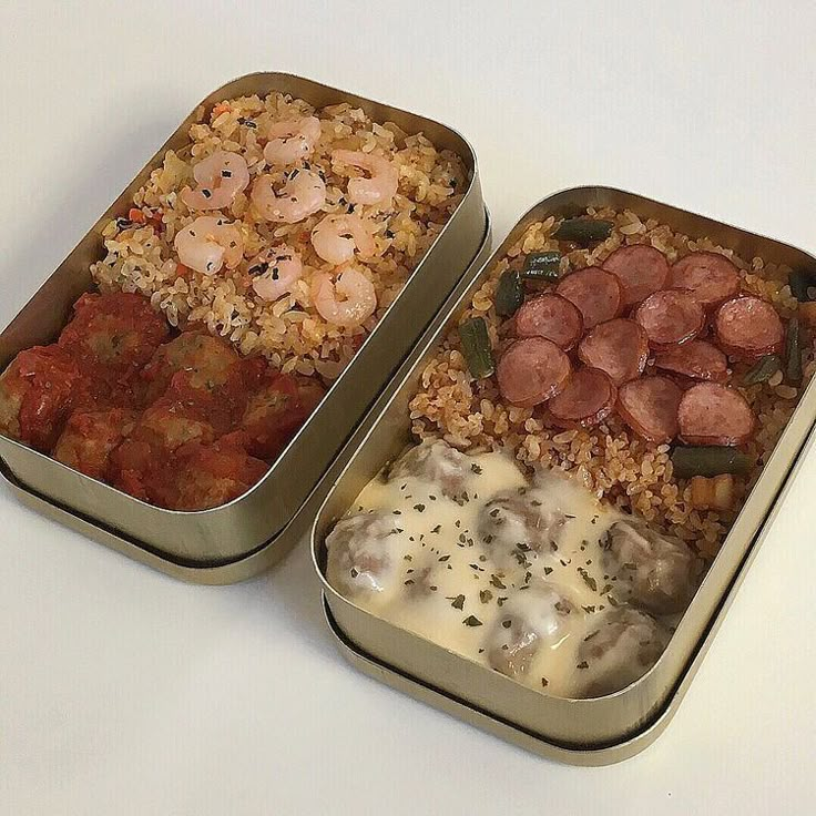 two tins filled with food sitting on top of a white table next to each other