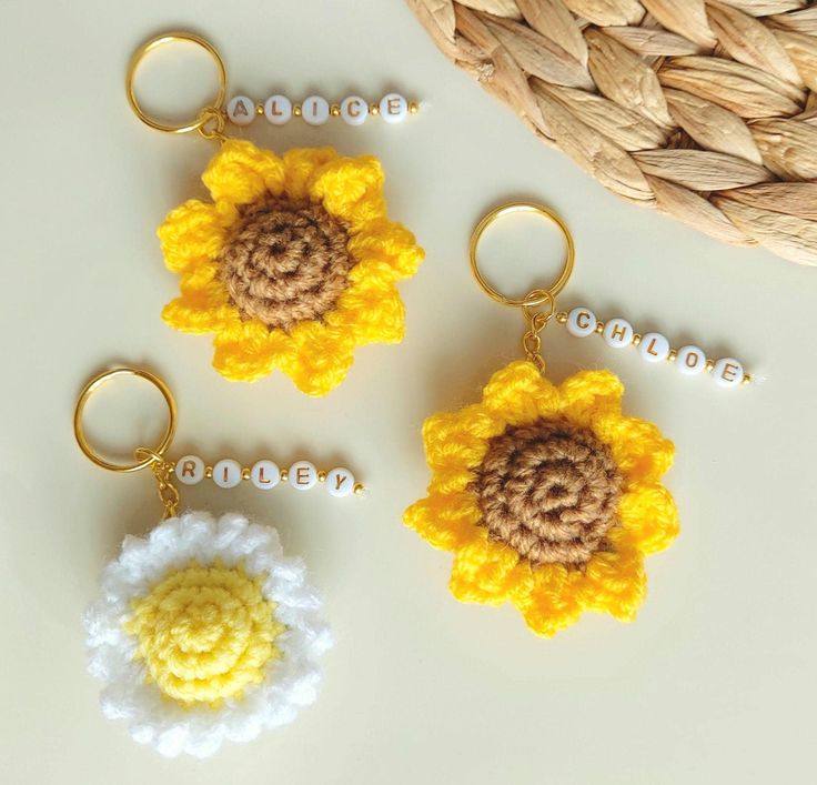 three crocheted keychains with flowers on them sitting next to each other