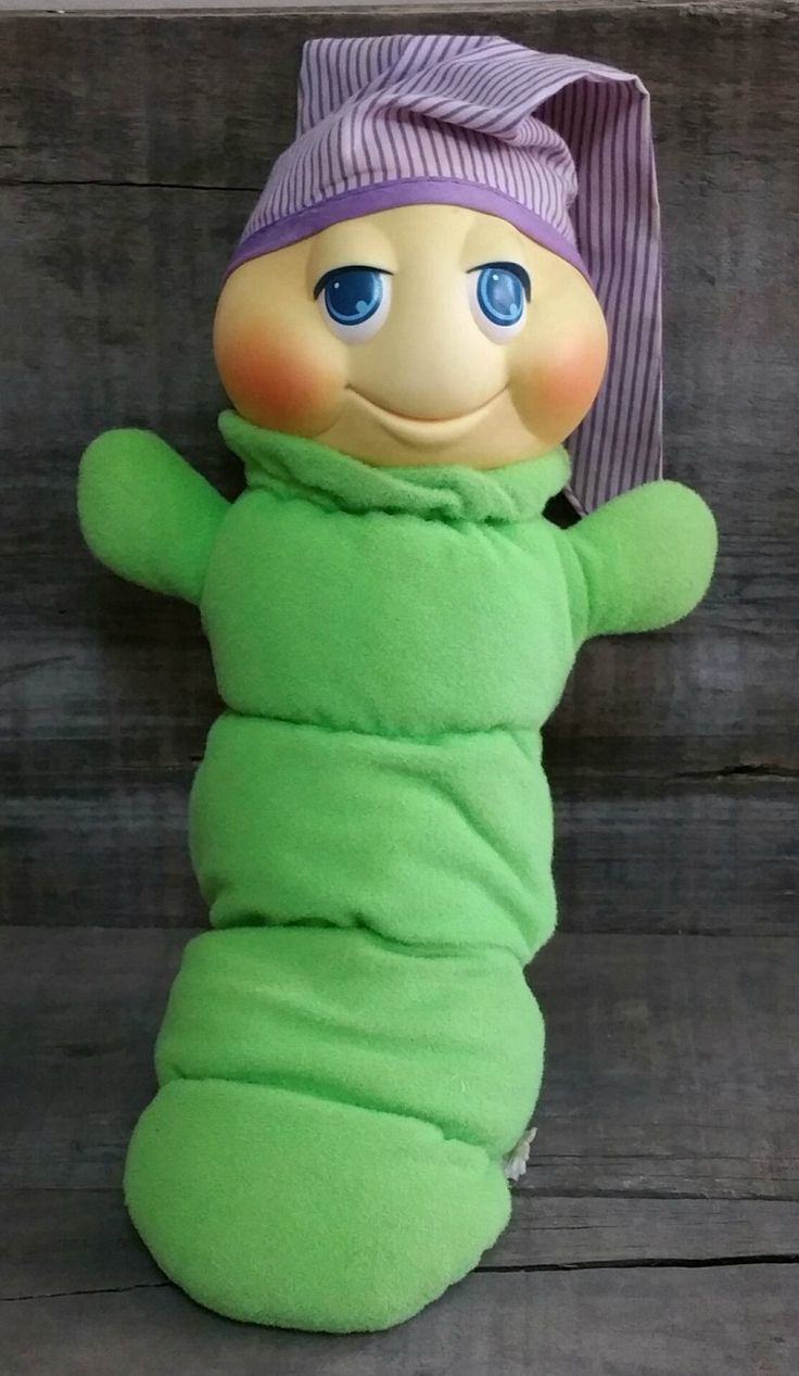 a stuffed caterpillar in a green outfit