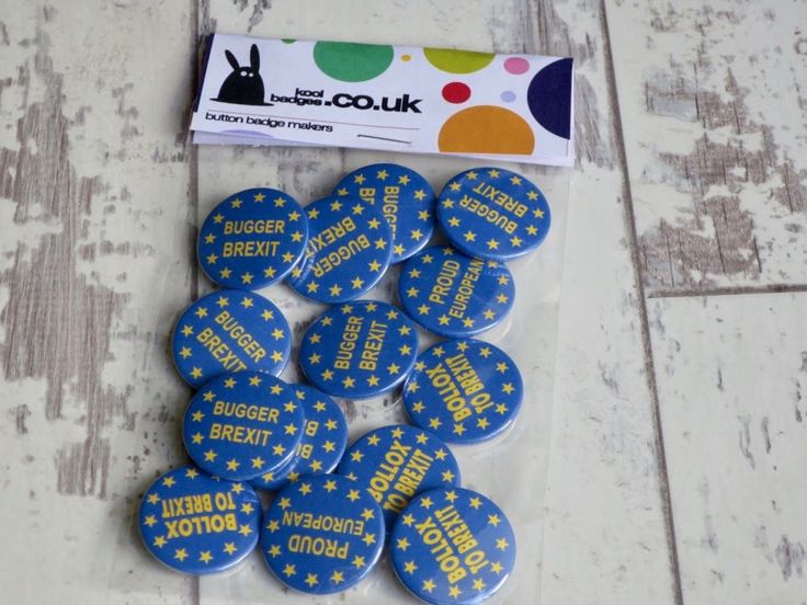 some blue and yellow buttons are on a white surface with a sticker next to it