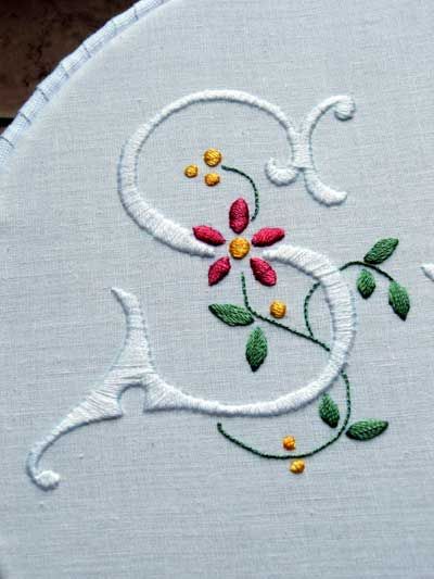 a white embroidered monogram with flowers on it