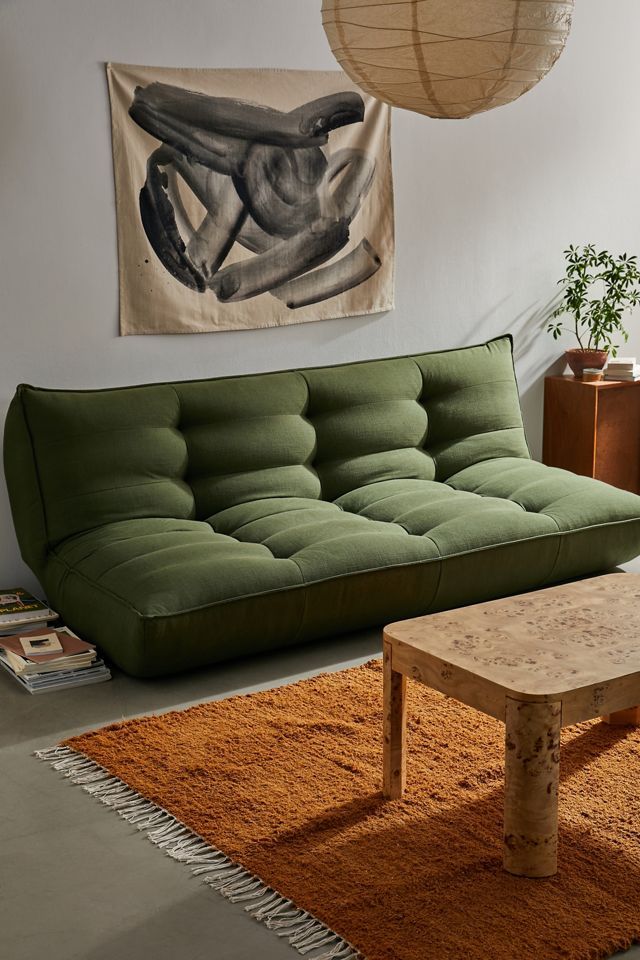 a living room filled with furniture and a painting hanging on the wall above an area rug