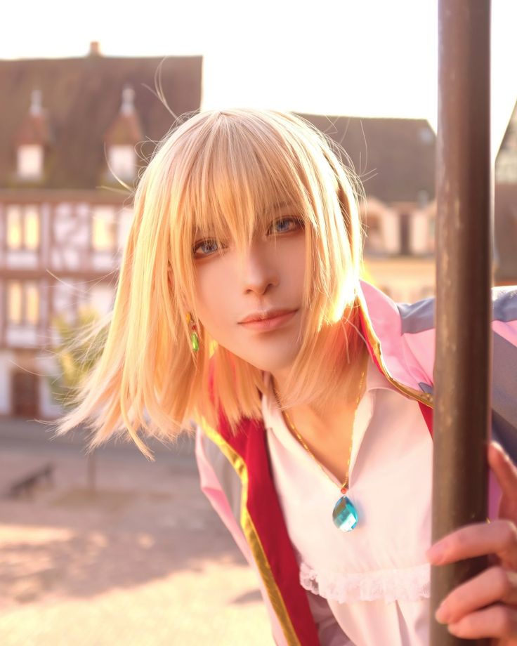 a blonde haired woman leaning against a pole