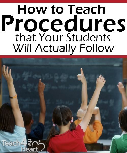 children raising their hands in front of a blackboard