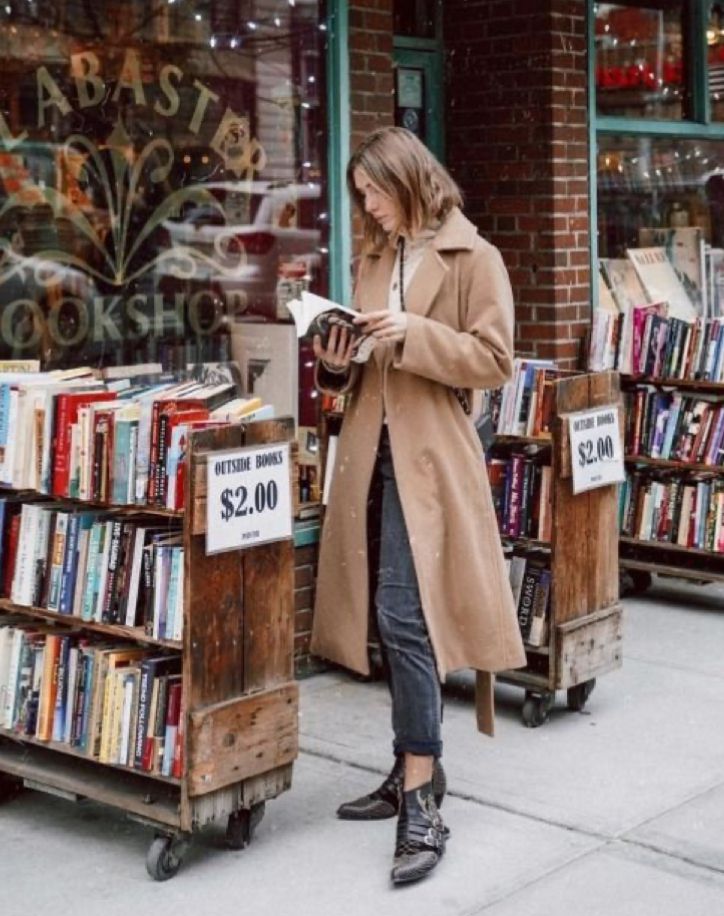 a woman standing in front of a book store