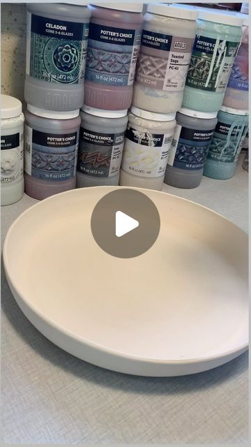 a white plate sitting on top of a counter next to some paint bottles and containers