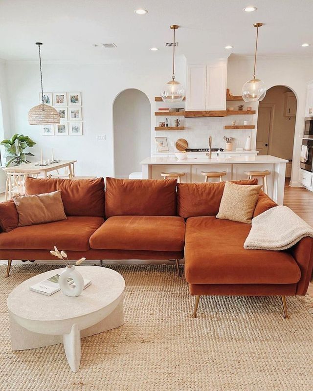 a living room filled with furniture next to a kitchen and an open concept floor plan