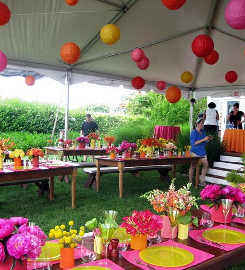 a tent with tables and chairs covered in paper lanterns