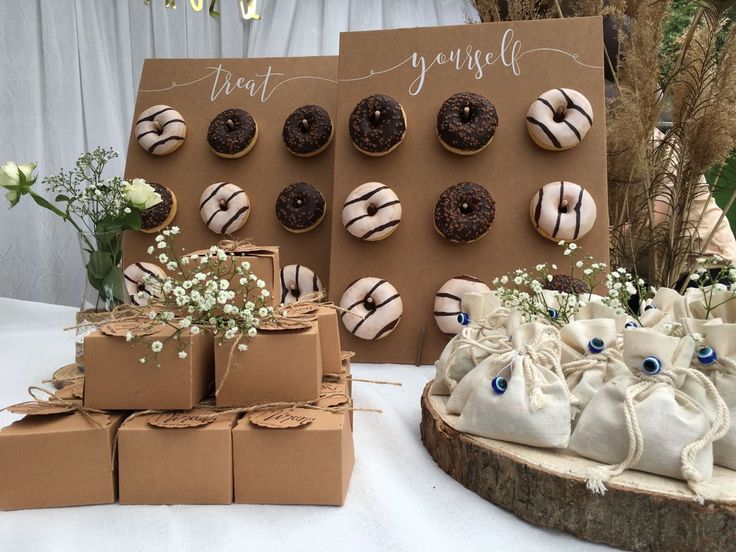 there are many donuts on the table next to each other and some bags with flowers in them