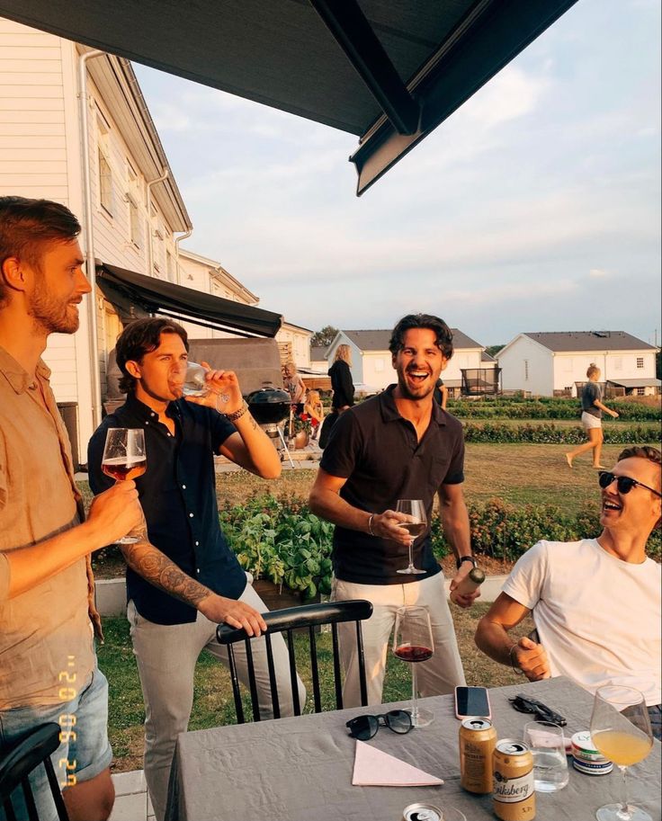 three men drinking wine at an outdoor table