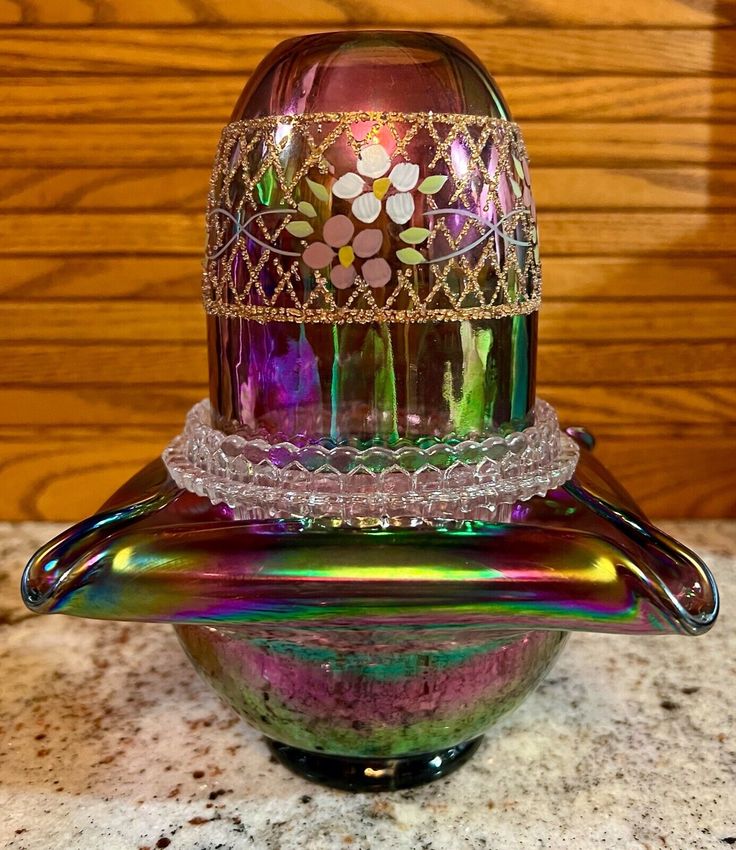 a colorful glass object sitting on top of a marble counter next to a wooden wall