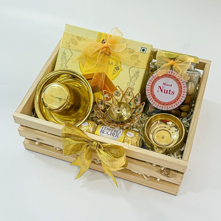 a wooden box filled with golden items on top of a white tablecloth covered floor