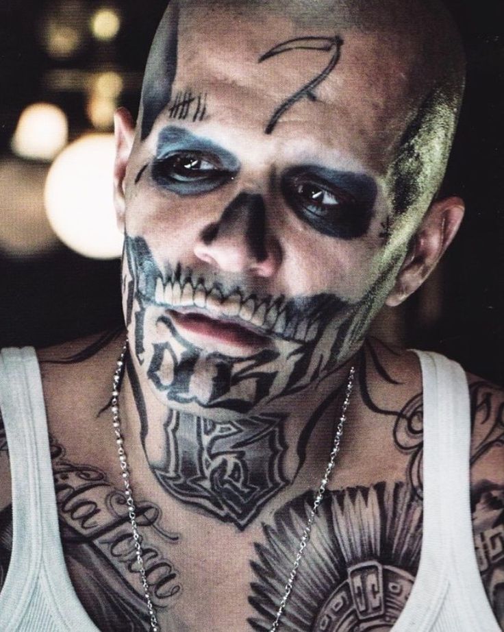 a man with tattoos on his face and chest