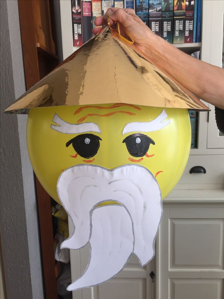 a balloon with a face on it being held up by a person's hand