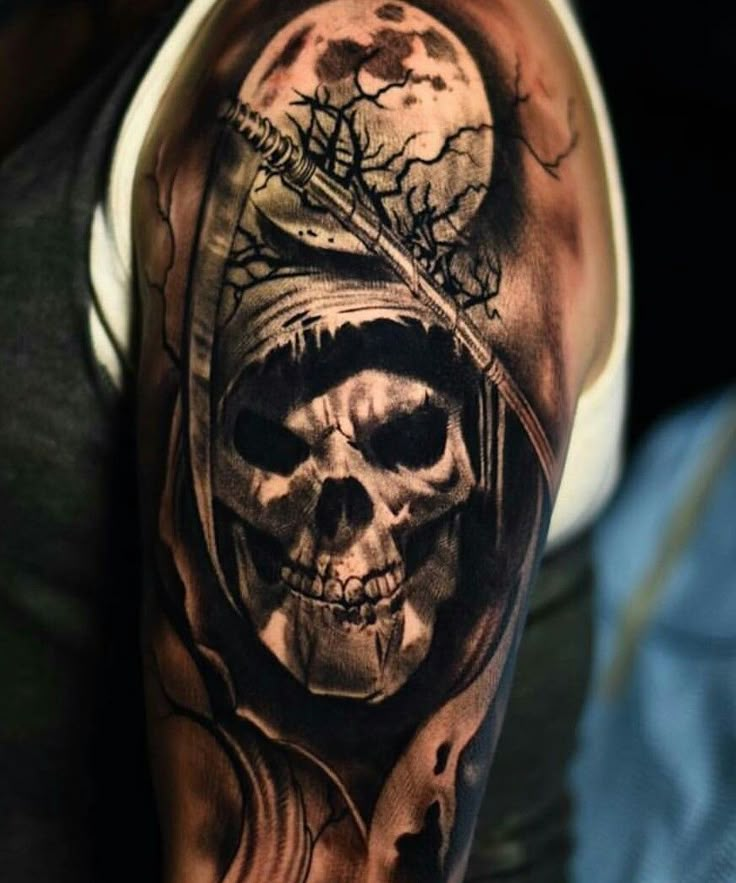 a man's arm with a skull wearing a hoodie and a tree on it