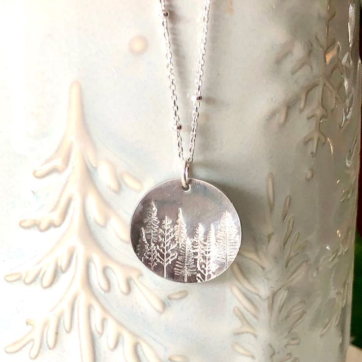 A stunning silver pine tree necklace for the nature lover! This piece is hand stamped with a lovely forest scene of our beautiful surroundings. A perfect gift to give the nature enthusiast! 🌿 Chain is a solid sterling silver satellite chain. You may choose your length at checkout. 🌿 Choose to have stars in your sky, or without. (shown in photos) 🌿 Silver disk is 2cm in diameter and made from alkeme. Please see all photo's for size reference. Alkeme is lead, nickel, and cadmium free and tarnis Forest Necklace, Leather Jewelry Making, Hand Stamped Ring, Stamped Earrings, Plant Jewelry, Tree Jewelry, Stamped Bracelet, Precious Gemstones Jewelry, Hand Stamped Necklace