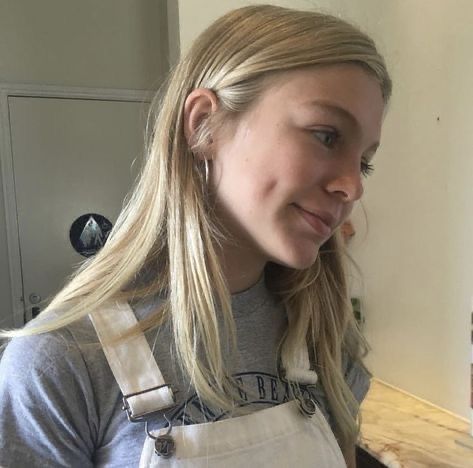 a woman with long blonde hair wearing an apron