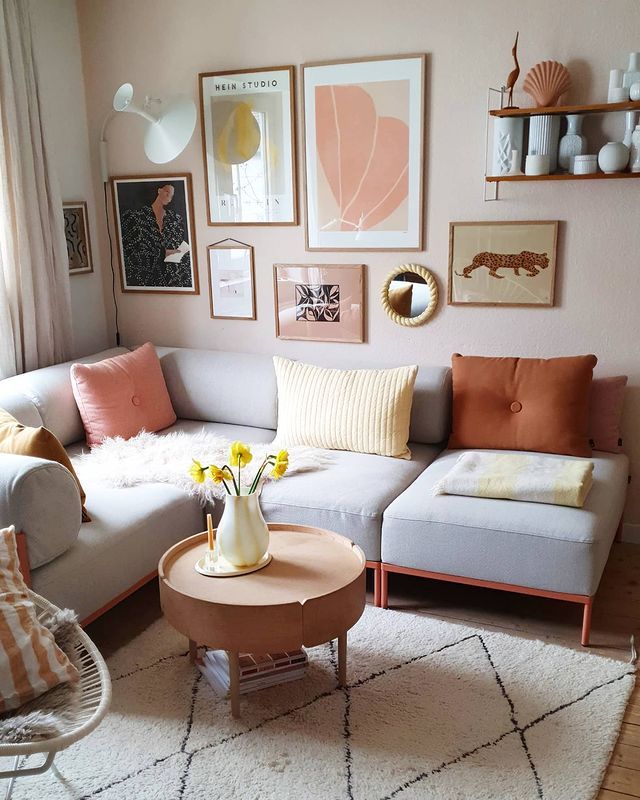 a living room filled with lots of furniture and pictures on the wall above it's coffee table