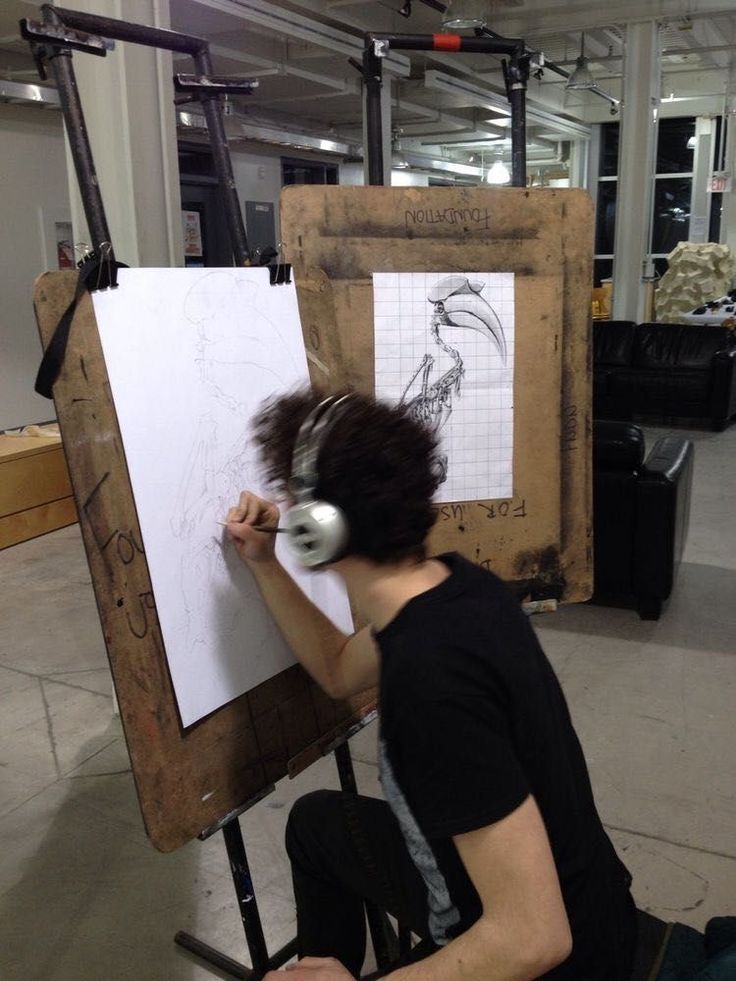 a man sitting in front of a drawing board