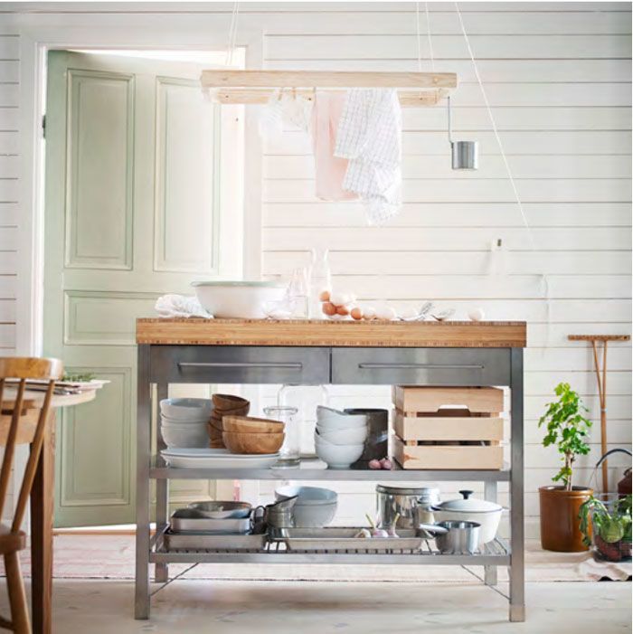 a kitchen island with pots and pans on it in the middle of a room