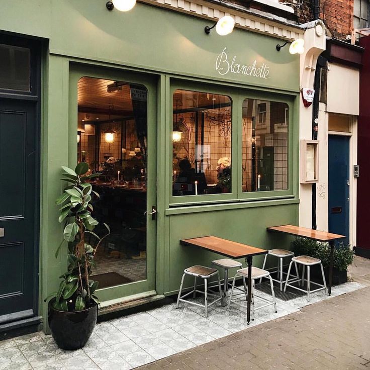 the outside of a restaurant with tables and chairs