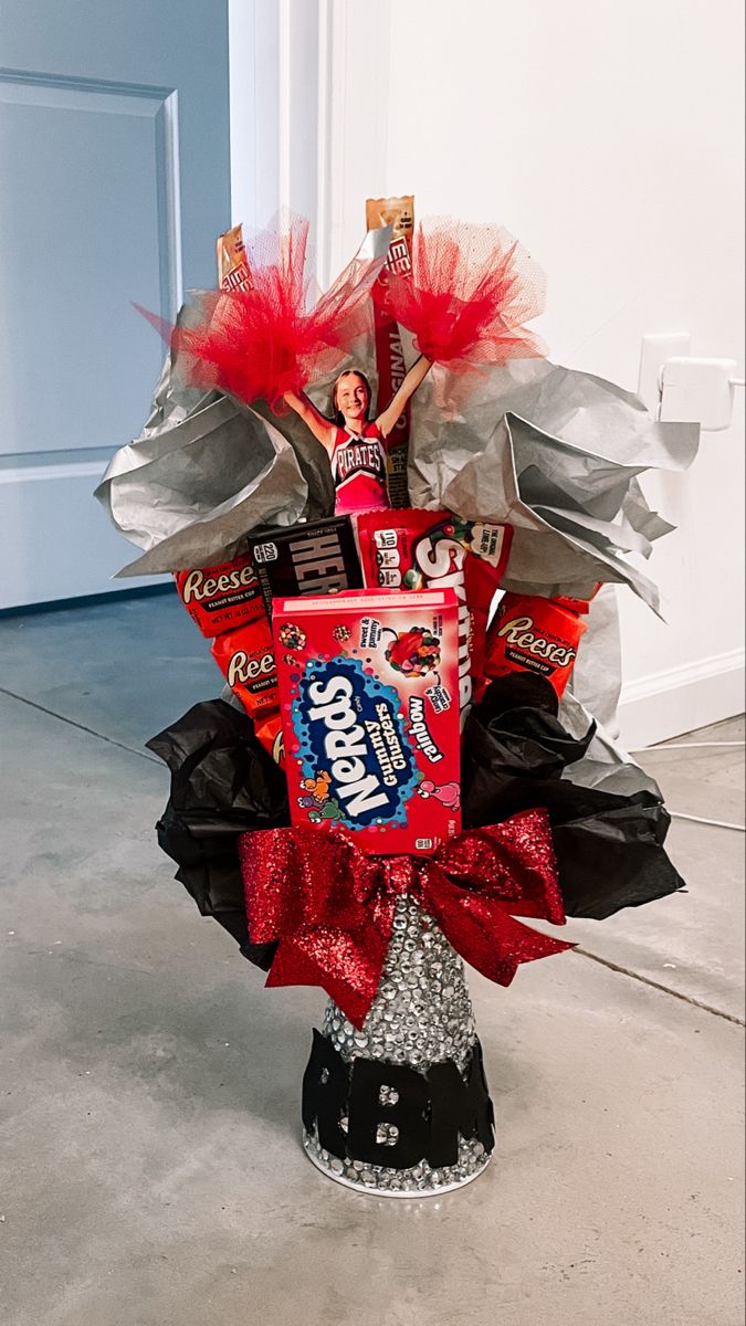 the candy bouquet is sitting on the floor in front of a door with red and black decorations