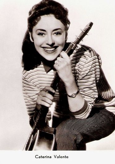 an old photo of a woman holding a guitar