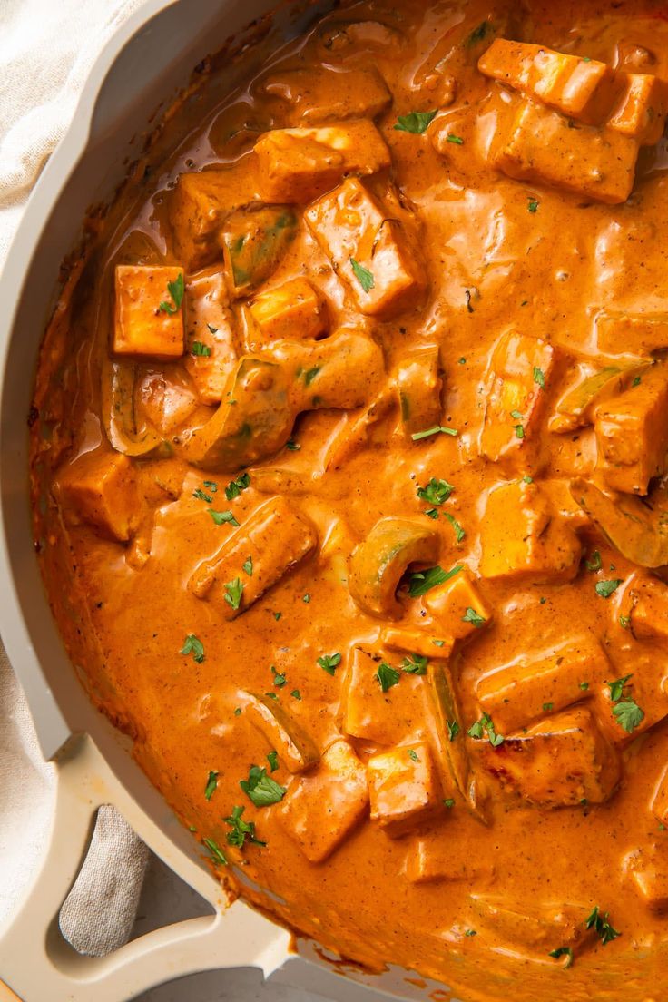 a pan filled with tofu and sauce on top of a table