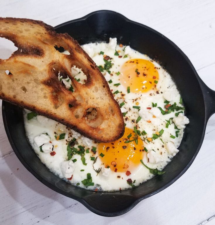 eggs and toast in a skillet on a white table