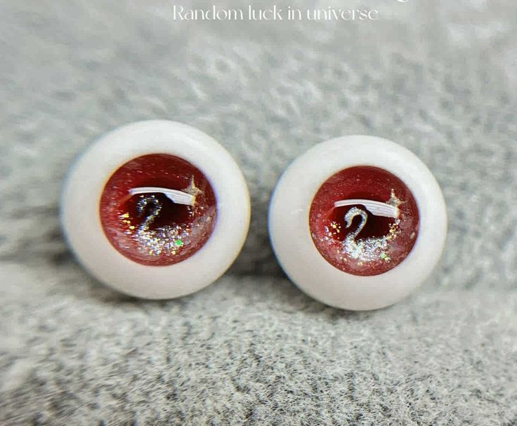 two white and red fake eyeballs with glitter on them