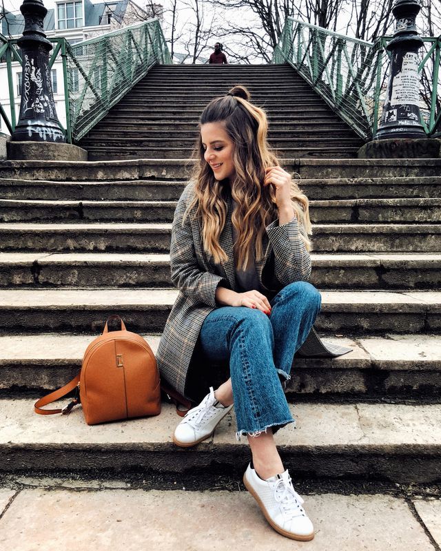 a woman sitting on some steps with her handbag