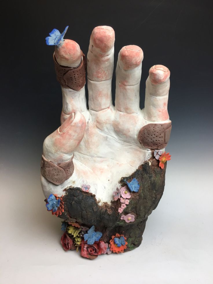 a sculpture of a hand with flowers on it