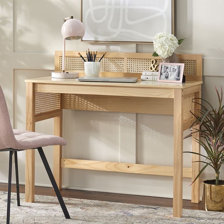 a wooden desk with a chair next to it and pictures on the wall behind it