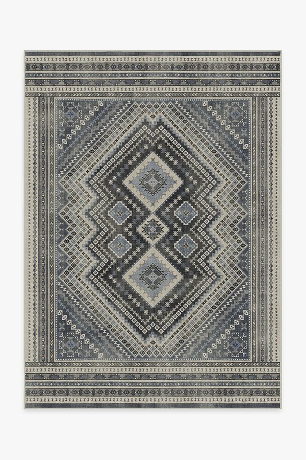 a rug with an intricate design in grey and white colors, on a gray background