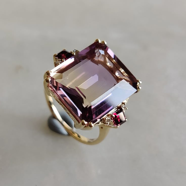 ITEM DESCRIPTION: --> The ring is made from Solid 14K Yellow Gold. Gemstone used is absolutely natural and ethically sourced.  --> Ametrine is naturally occurring gemstone which is a unique combination of Amethyst and Citrine.  --> Ametrine in Emerald Cut is studded with fine quality Rodo garnet and diamond  on its utmost precision. Gem: Ametrine Gem size: 17 x14 mm Gem shape : octogon Gem weight: 10.70 carat Gem : Rodo Garnet Gem size : 3 mm (2 pcs) Gem shape : Square  Gem weight : 0.38 CTS Gem : Diamond Gem size :1.5 mm Gem shape : Round Brilliant (4 pcs) Gem weight : 0.058 cts Gold purity: 14K (58.33% approx.) Gold weight: 3.72 grams  Total Gem weight : 11.14 cts Gross weight of ring: 5.95 grams >>The Gold purity is guaranteed and it comes with authentic 14K gold hallmark. >>Since these Luxury Gold Birthstone Ring With Diamond Accents, Luxury Classic Amethyst Ring With Gemstone Accents, Luxury Unique Gold Birthstone Ring, Square Gem Ring, Garnet And Amethyst Ring, Ring Settings For Oval Stones, Large Gemstone Rings, Unique Ring Settings, Sagittarius Birthstone