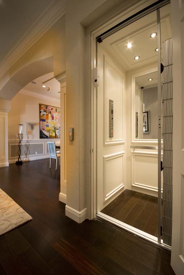 an open door leading to a living room with hardwood floors and white walls, along with a painting on the wall