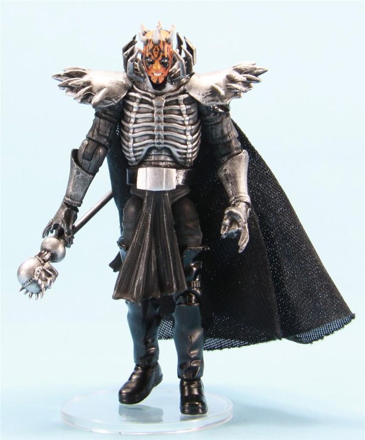 the action figure is dressed in black and silver armor, with large wings on his head