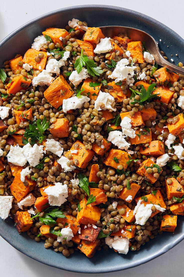 a blue bowl filled with lentils and sweet potatoes